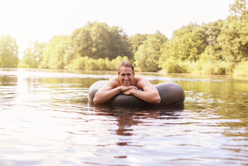 Man Floating in Inner tube on River